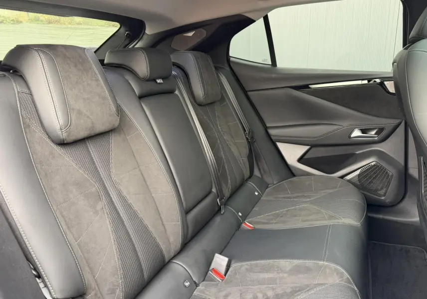 Vue intérieure des sièges arrière en Alcantara noir et tissu tressé sur DS4 2025, avec panneaux de porte assortis.