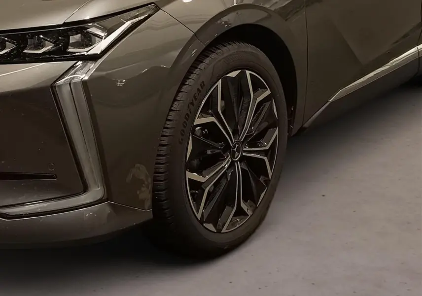 Gros plan sur la roue avant droite et le passage de roue d'une DS4 gris Platinium avec feux LED verticaux distinctifs.