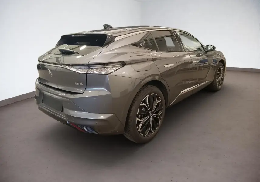 DS4 2025 gris Platinium en 3/4 arrière droit, avec jantes alliage et vitres teintées sur fond neutre.