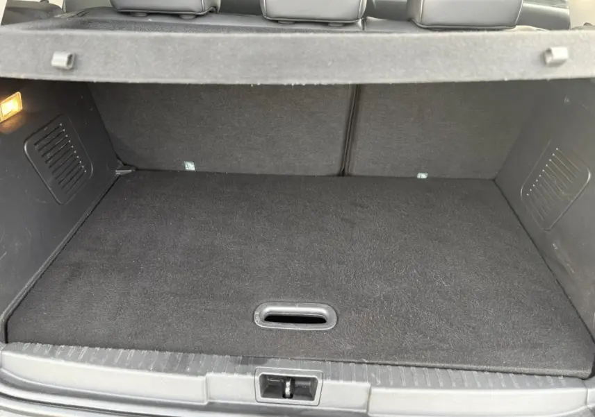 Vue intérieure du coffre du Renault Captur 2017, montrant un espace de rangement propre et bien fini en tissu noir.