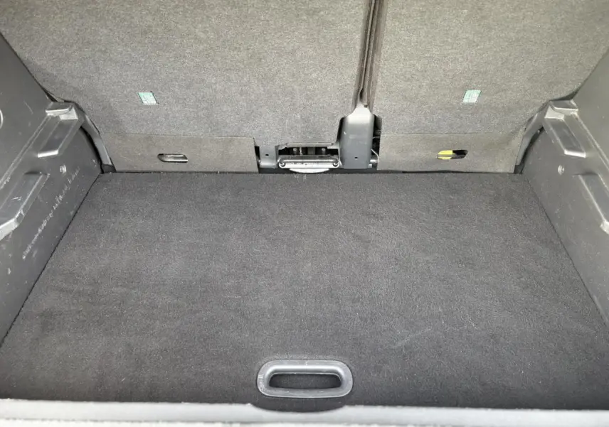 Vue du coffre arrière du Renault Captur gris Cassiopée, montrant le plancher plat et la banquette rabattue.