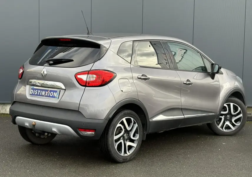 Vue 3/4 arrière droite d’un Renault Captur gris Cassiopée avec jantes alliage noires et vitres surteintées.