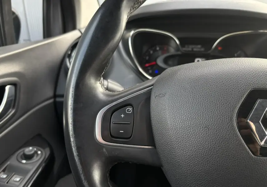 Gros plan sur le volant cuir noir du Renault Captur 2017, montrant les commandes de régulateur côté gauche.