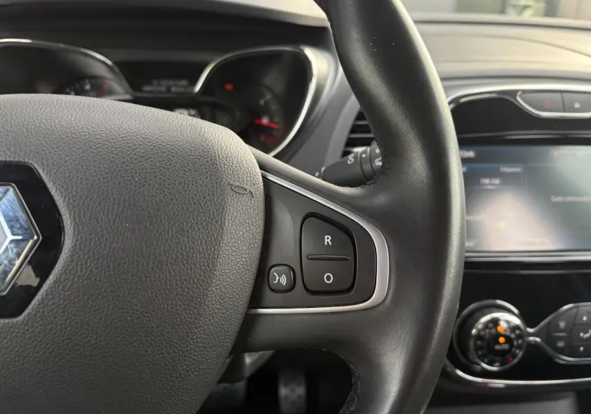 Gros plan sur le volant cuir noir du Renault Captur 2017 avec commandes intégrées et écran tactile du système multimédia.