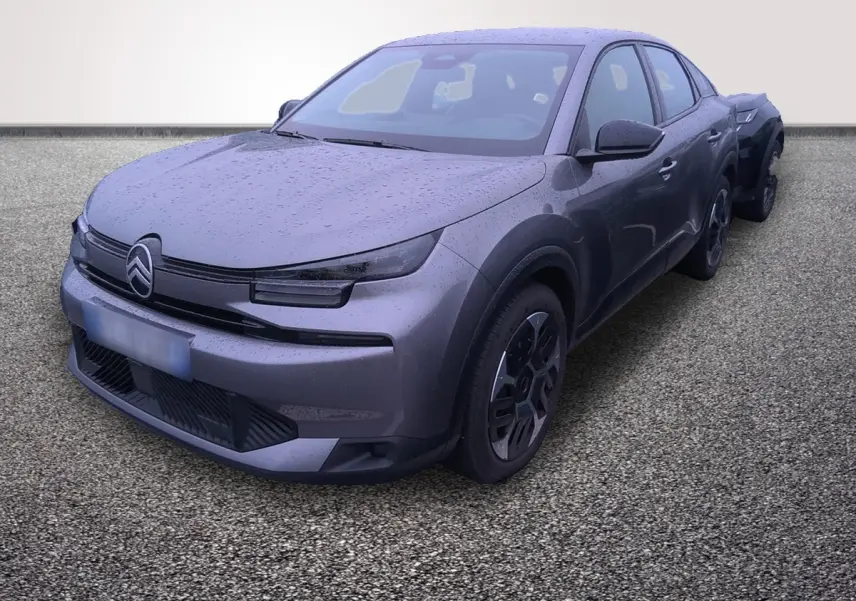 Vue 3/4 avant droite d'une Citroën C4 hybride gris foncé avec pluie visible sur la carrosserie.