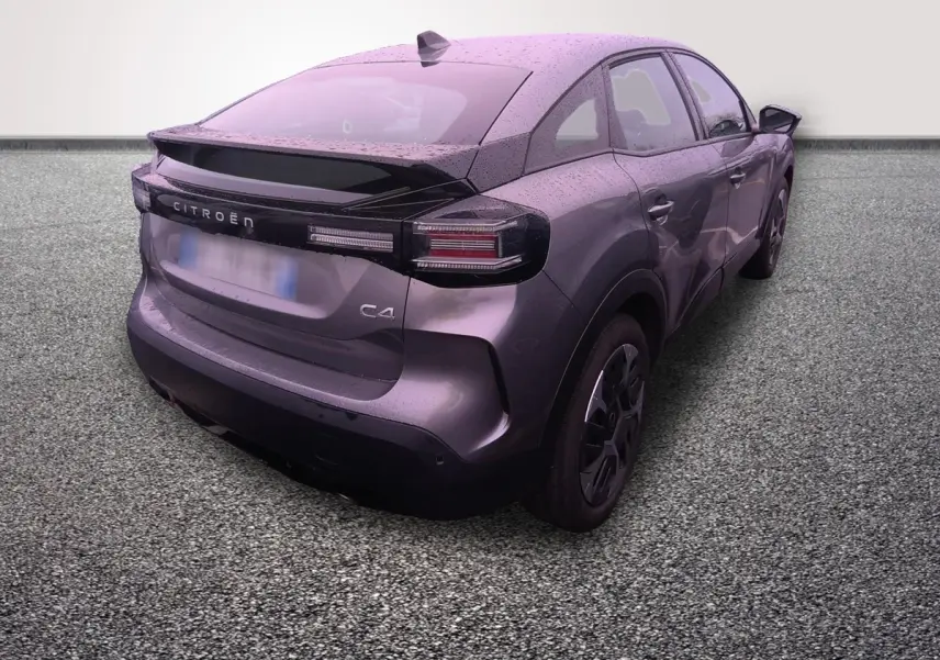 Vue 3/4 arrière droite d'une Citroën C4 hybride gris foncé avec spoiler et feux arrière LED distinctifs.