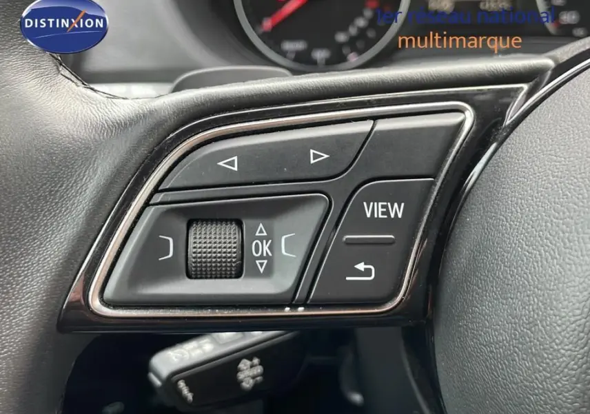 Gros plan sur les commandes multifonctions à gauche du volant d'un Audi Q2 35 TFSI noir mito metal de 2023.