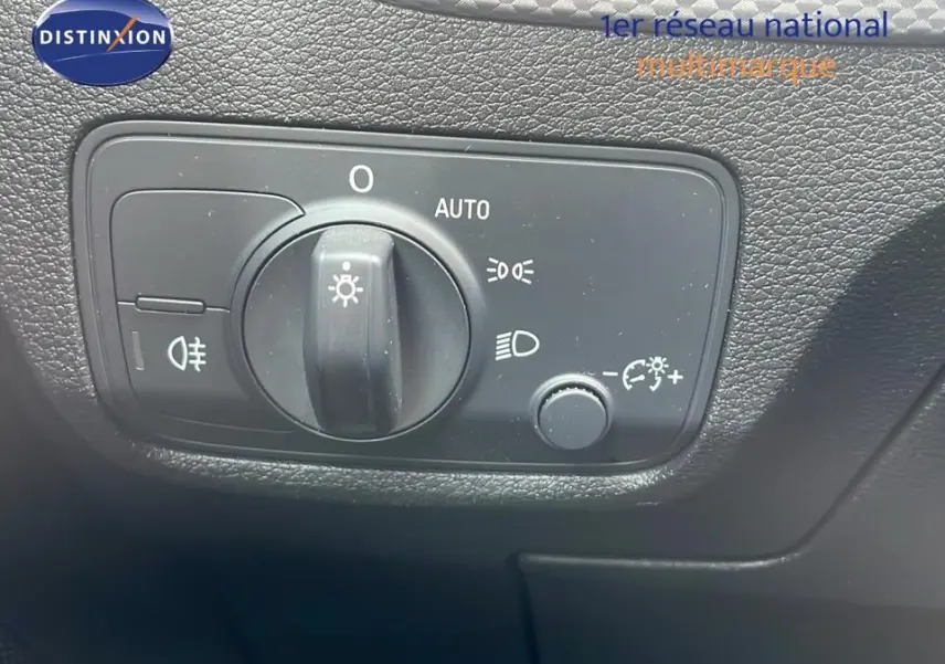 Gros plan sur le bouton de commande des phares dans l'habitacle noir de l'Audi Q2 35 TFSI S-Line 2023.