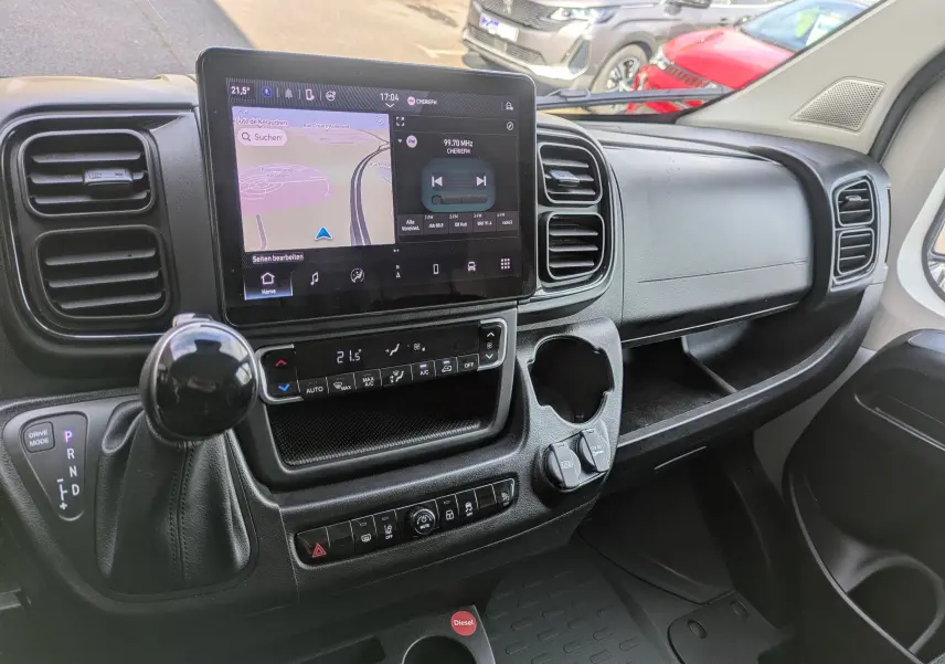 Vue intérieure du tableau de bord du Peugeot Boxer Fourgon blanc, avec écran tactile central et levier de vitesses automatique.