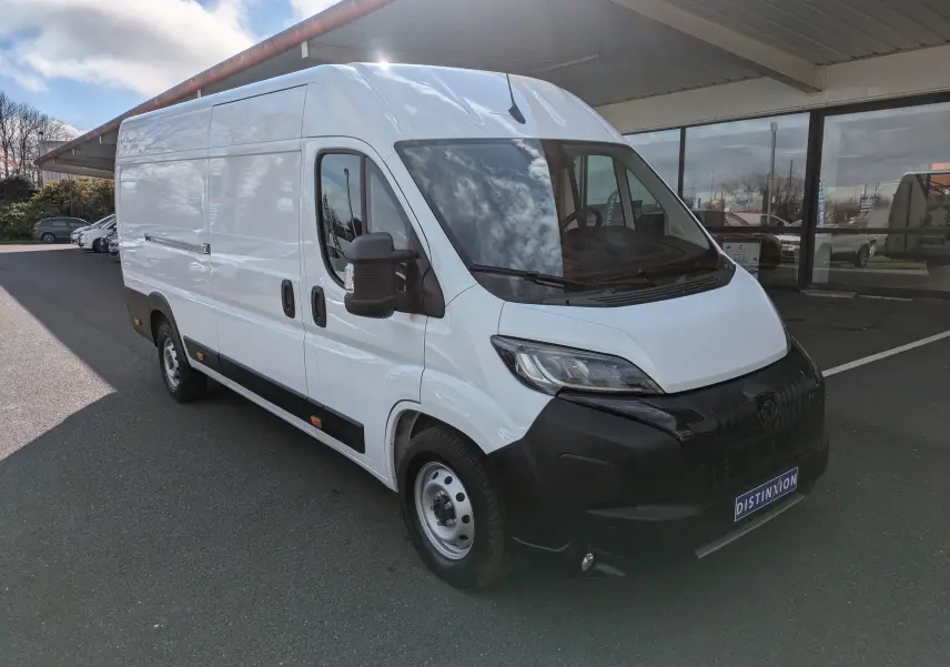 Vue 3/4 avant droit d’un Peugeot Boxer Fourgon blanc 2025 avec portes latérales coulissantes et jantes acier 16 pouces.