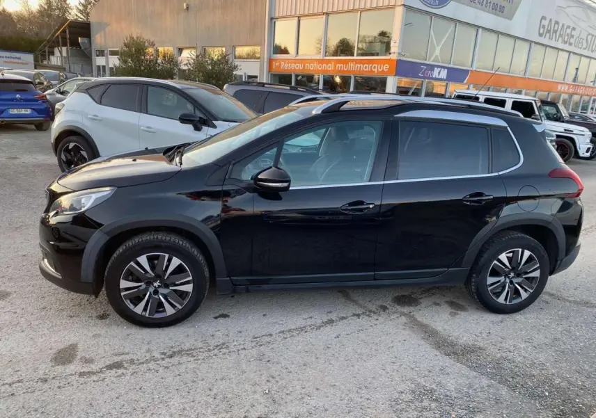 Profil côté gauche du Peugeot 2008 noir Perla Nera de 2017 avec jantes aluminium et bas de caisse noir mat.