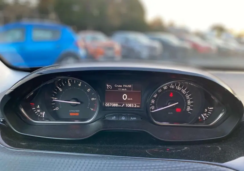 Vue rapprochée du tableau de bord de la Peugeot 2008 noir Perla Nera, affichant compteur et écran digital.