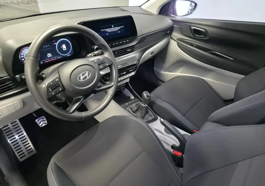 Vue intérieure côté conducteur du Hyundai Bayon 2025, volant cuir, tableau de bord numérique et console centrale grise.