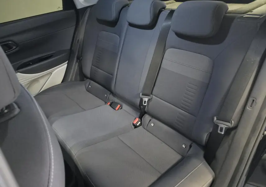 Vue intérieure du siège arrière noir du Hyundai Bayon 2025 avec ceintures de sécurité et appuie-têtes réglables.