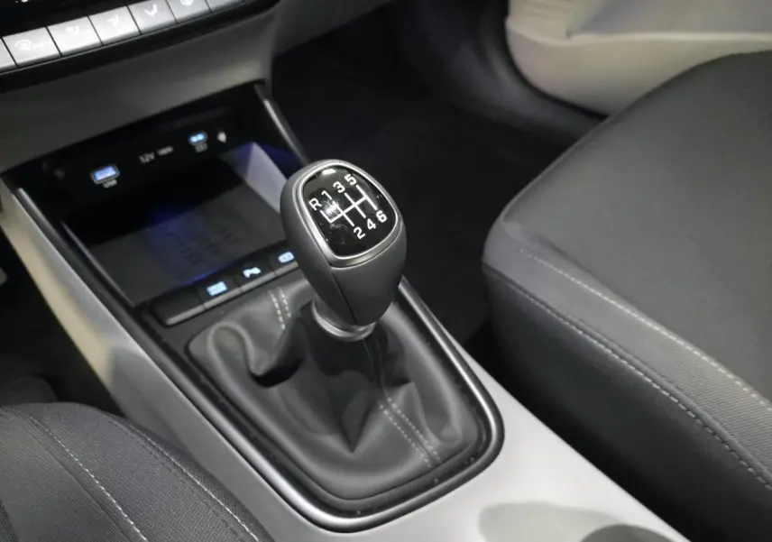 Gros plan sur le levier de vitesses manuel noir et gris clair de la Hyundai Bayon 2025, côté console centrale.