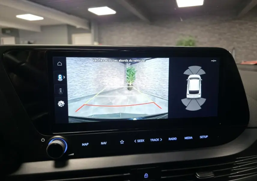 Écran tactile intérieur montrant la caméra de recul active avec vue arrière et capteurs de proximité du Hyundai Bayon noir.