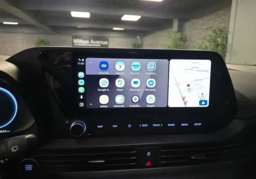 Vue rapprochée de l'écran tactile central du tableau de bord de la Hyundai Bayon noire avec interface connectée et commandes lumineuses.