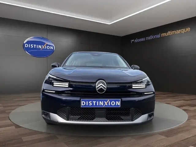 Vue frontale d'une Citroën C4 hybride 2025 bleu foncé avec phares LED et logo distinctif au centre.