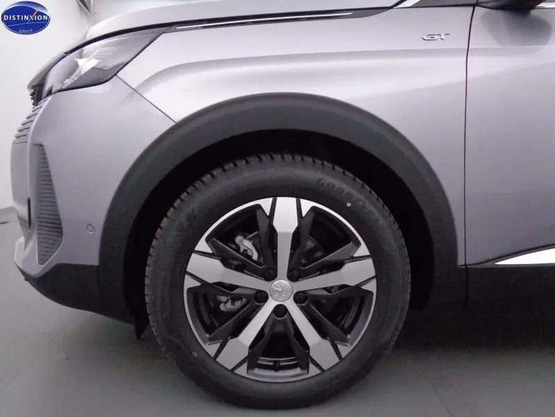 Gros plan sur la roue avant gauche et l'aile gris Artense du Peugeot 3008 GT 2023 avec logo GT visible.