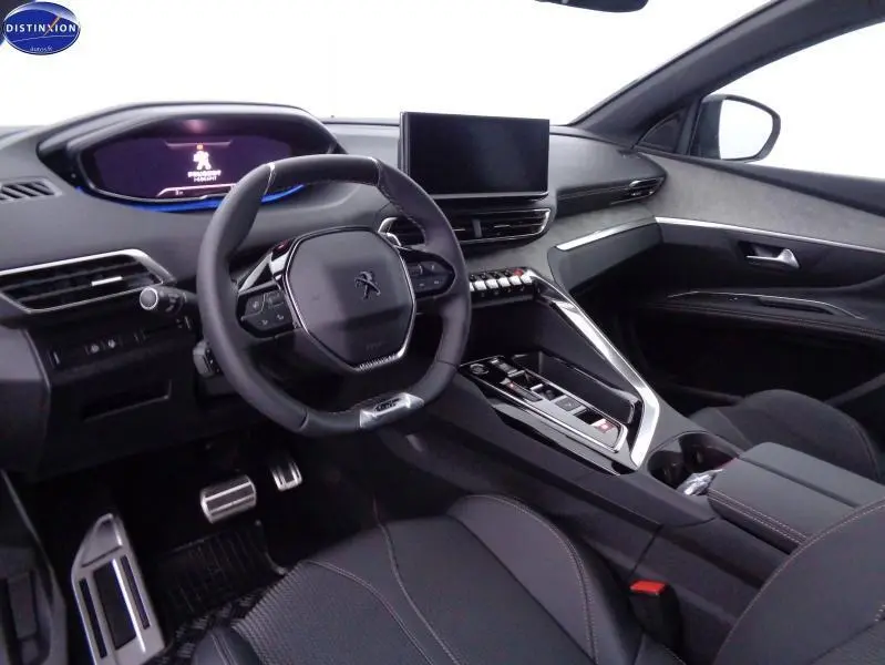 Intérieur avant du Peugeot 3008 2023 en gris, avec volant cuir compact et écran tactile central visible.