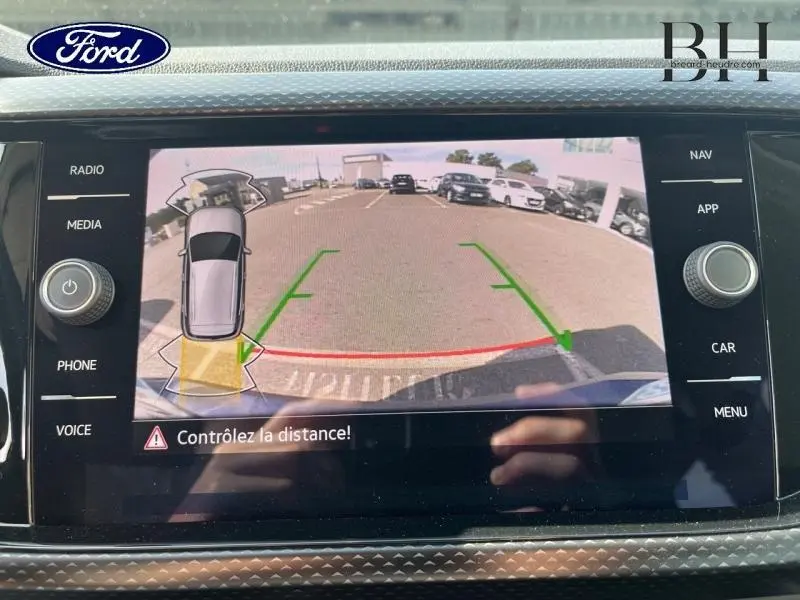 Affichage de la caméra de recul du Volkswagen T-Cross gris cendré, vue arrière avec lignes de guidage vertes et rouges.