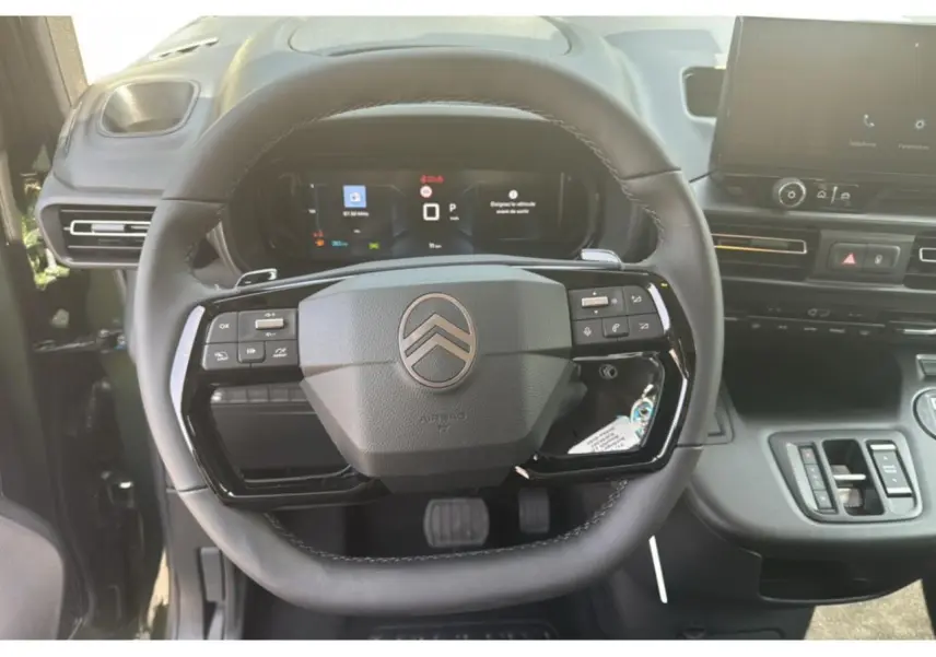 Vue rapprochée du volant multifonction noir et du tableau de bord numérique du Citroën Berlingo 2025.