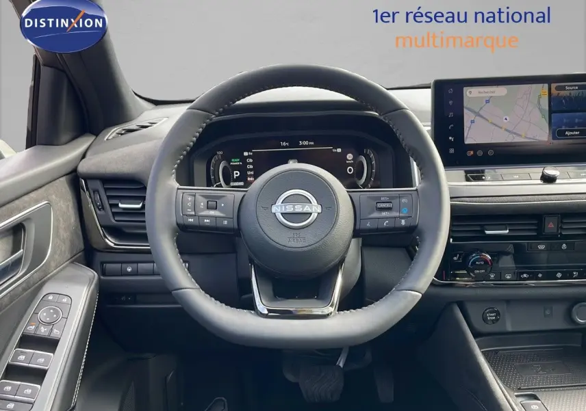 Vue intérieure du tableau de bord du Nissan Qashqai 2025, volant cuir noir et écran tactile avec navigation.