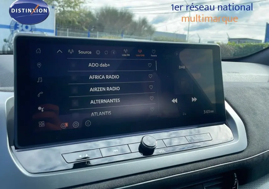 Écran tactile central affichant les stations radio DAB+ dans l'habitacle du Nissan Qashqai blanc nacré 2025.