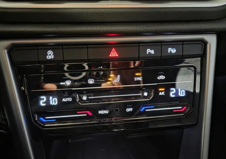 Panneau de commande de la climatisation bi-zone du Volkswagen T-Roc Cabriolet gris 2024, affichage digital à 21°C.