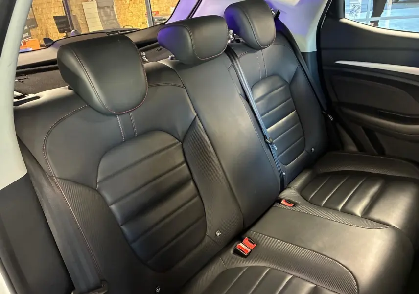 Vue intérieure sur les sièges arrière en cuir noir du MG ZS 1.0 TGDI 111 BVA Luxury 2022, avec surpiqûres rouges.