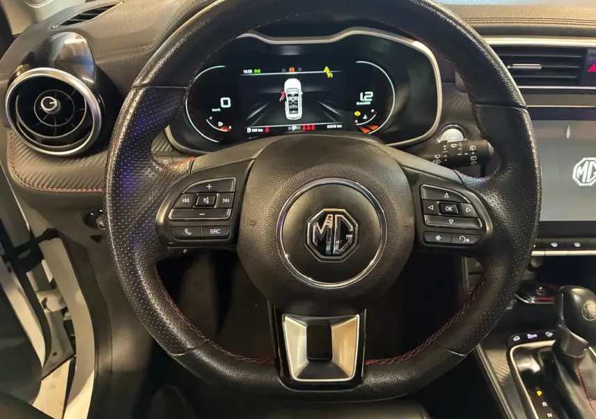 Vue centrée sur le volant en cuir noir du MG ZS 2022 avec tableau de bord numérique et console centrale visible.