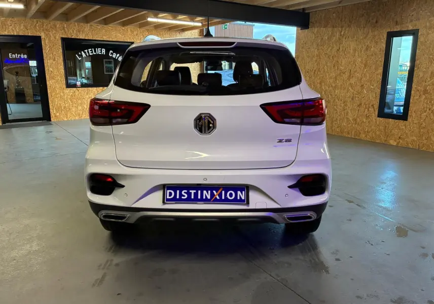Vue arrière d’un MG ZS blanc 2022 en version Luxury, avec feux rouges et double sortie d’échappement visible.