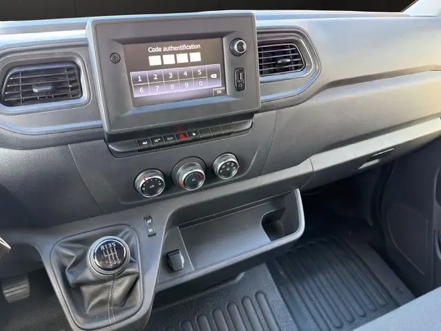 Vue intérieure du tableau de bord du Renault Master blanc 2023, avec écran tactile, commandes clim et levier de vitesses manuel.