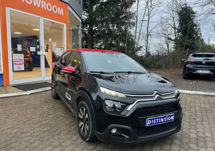 Citroën C3 Shine 2023 vue 3/4 avant droit, noir avec toit et rétroviseurs rouges, jantes alliage diamantées.