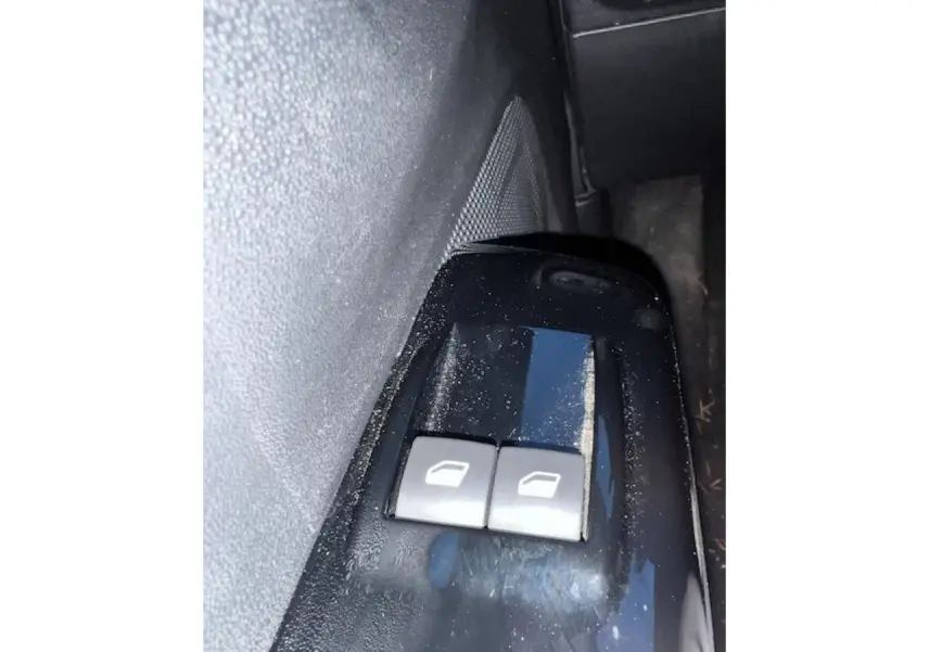 Gros plan sur les commandes des vitres électriques côté conducteur de la Citroën C3 Shine 2023 noir toit rouge.