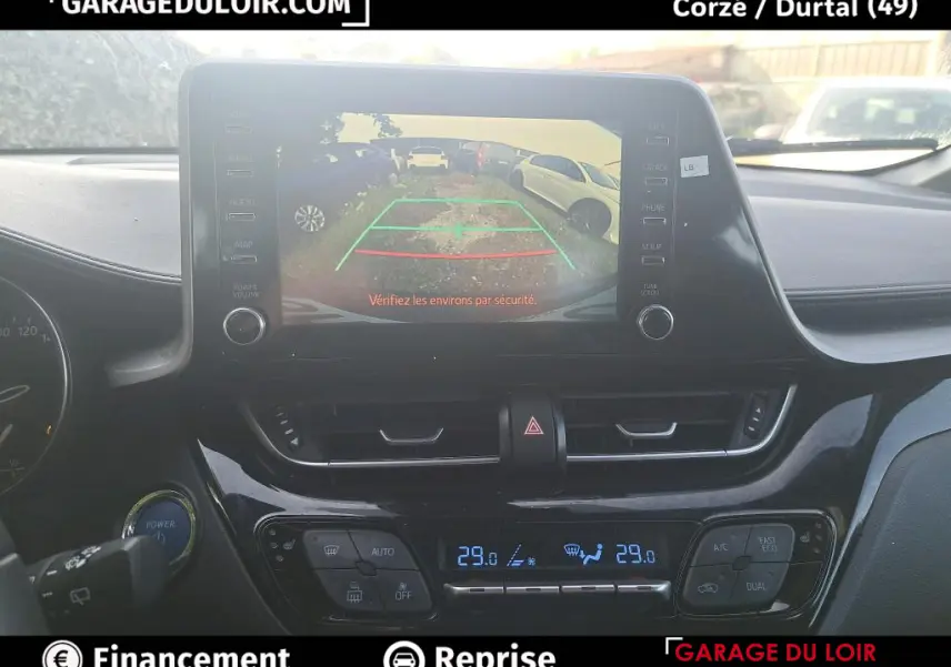 Vue intérieure du tableau de bord du Toyota C-HR 1.8 Hybride 2023 avec écran tactile affichant la caméra de recul.