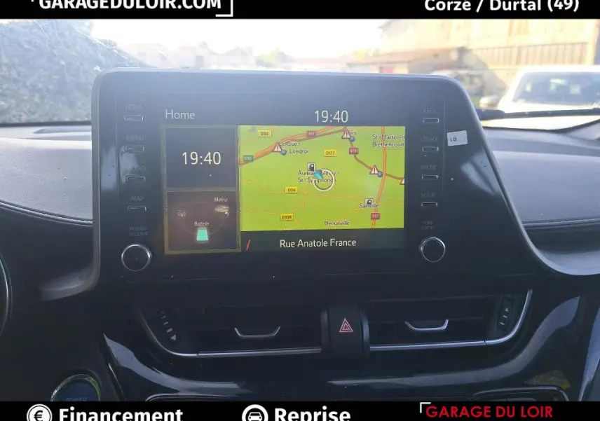 Vue rapprochée de l’écran tactile central du Toyota C-HR 2023 affichant la navigation et l’heure, intérieur noir.