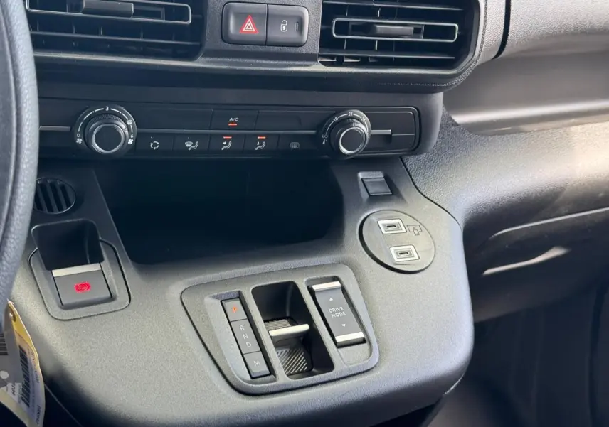 Vue rapprochée de la console centrale noire du Citroën Berlingo Fourgon XL Diesel 130ch avec commandes de climatisation et boîte automatique.