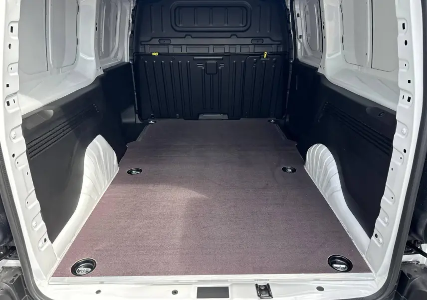 Vue intérieure arrière du Citroën Berlingo Fourgon XL blanc Icy, montrant l’espace de chargement vide et protégé.
