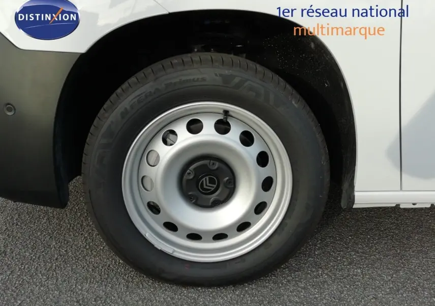 Gros plan sur la roue avant gauche d’un Citroën Berlingo XL blanc Icy, avec jante acier et logo Citroën central.