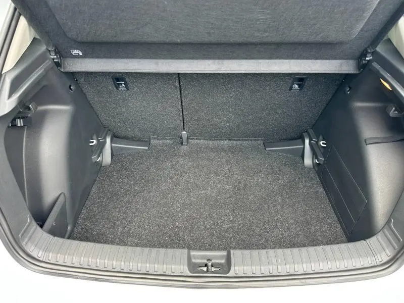 Coffre ouvert vu de face d'une Skoda Fabia 2024, intérieur noir avec tapis de sol et éclairage latéral.