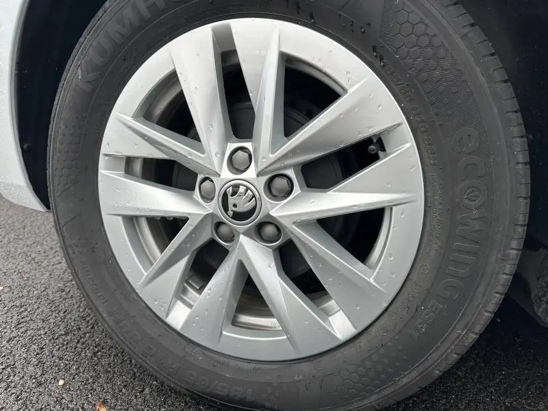 Gros plan sur la jante alu argentée d'une Skoda Fabia bleue 2024, mettant en valeur le logo central et le pneu Kumho Ecowing.