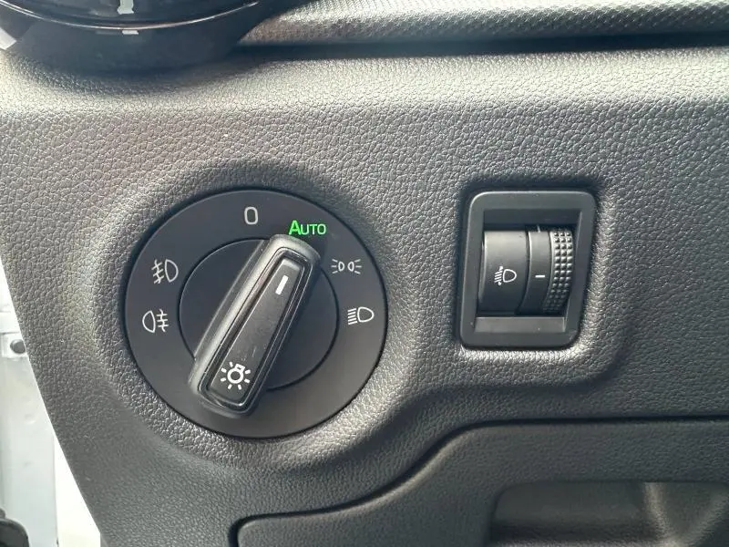 Gros plan sur le commutateur d'éclairage et le réglage des phares dans l'habitacle de la Skoda Fabia bleue 2024.