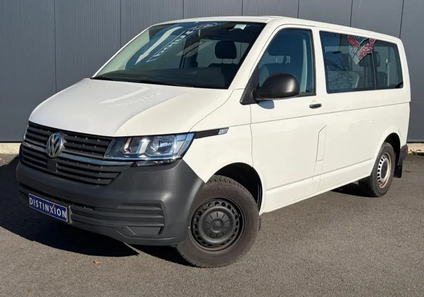 Vue 3/4 avant droit d’un Volkswagen Transporter T6 Minibus blanc avec pare-chocs noir et jantes acier.
