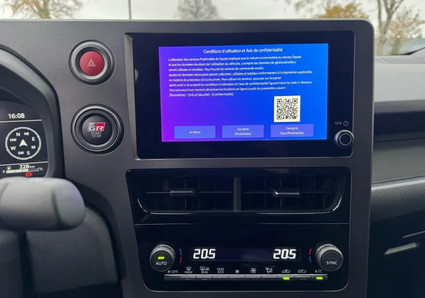 Vue intérieure centrée sur l’écran tactile et la console de la Toyota Yaris GR Pack Techno, avec commandes climatisation digitales.