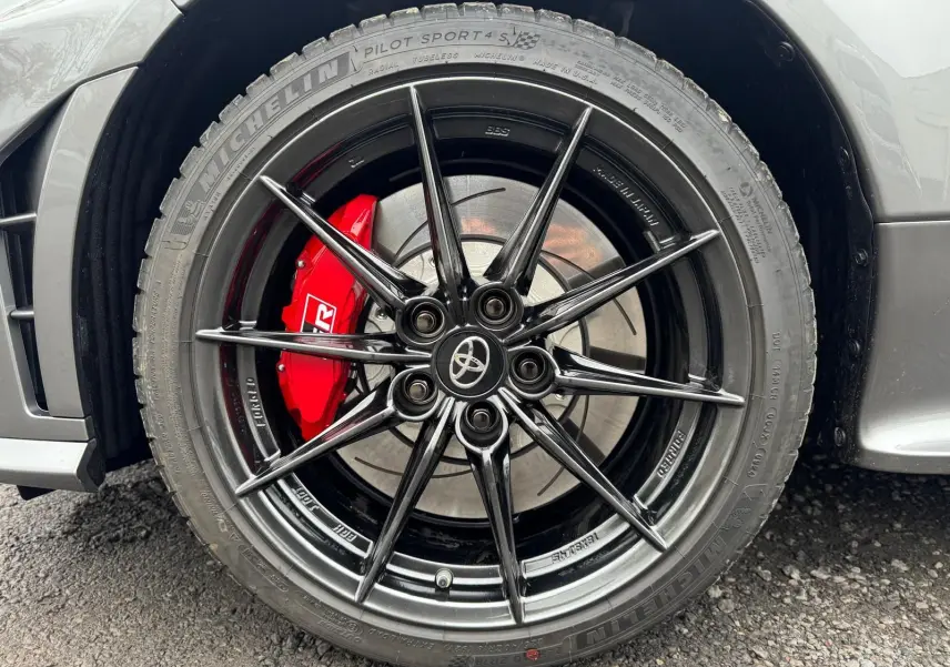 Gros plan sur la jante BBS noire forgée et le frein rouge marqué GR d'une Toyota Yaris Gris Platine.