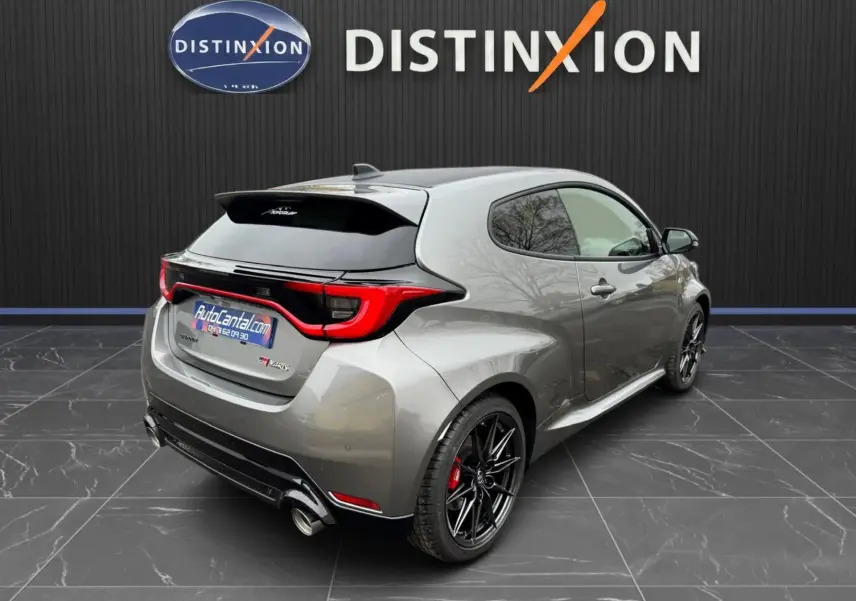 Toyota Yaris GR gris platine vue 3/4 arrière droit, jantes BBS noires et toit carbone visible.