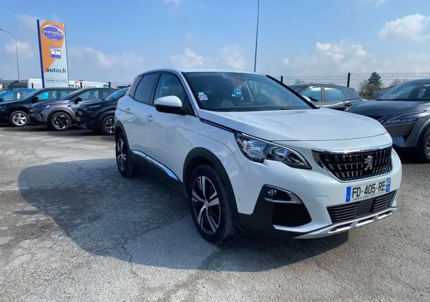 Peugeot 3008 blanc vue 3/4 avant droit, avec jantes alliage et calandre noire distinctive, sur parking extérieur.