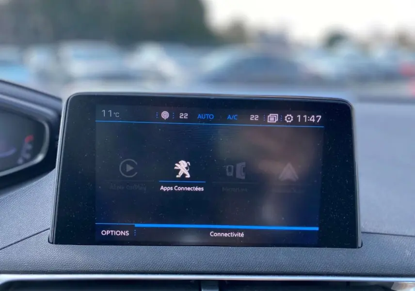 Écran tactile central du Peugeot 3008 blanc de 2018 affichant les applications connectées en intérieur.