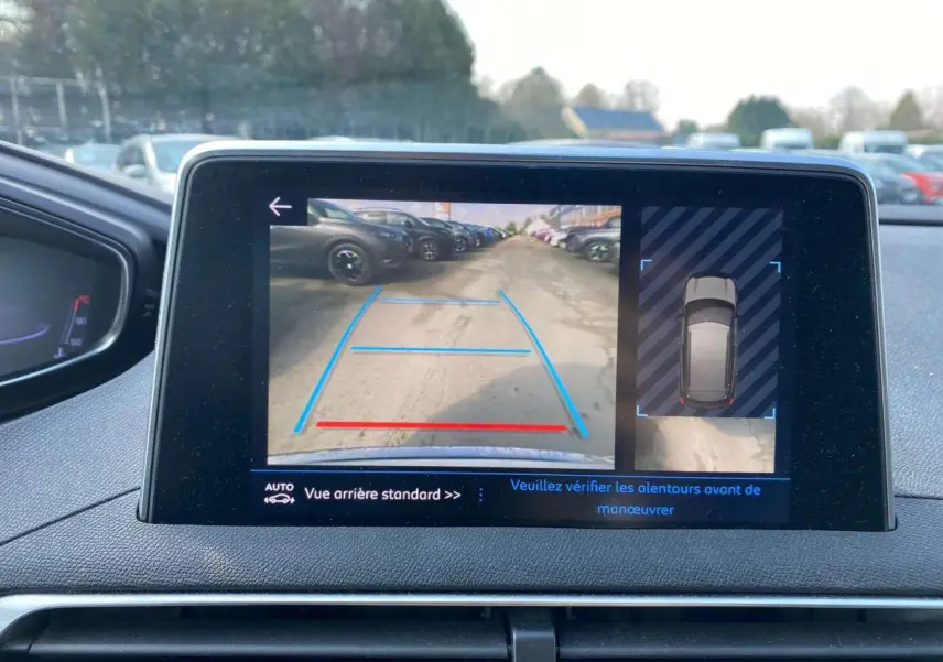 Écran central du Peugeot 3008 blanc montrant la caméra de recul avec aide au stationnement et vue 360° du véhicule.